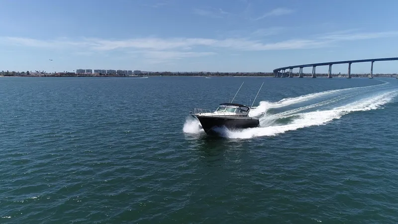Slide: The Image of A 1988 Californian Veneti boat cruising on open water near a long bridge. - 17