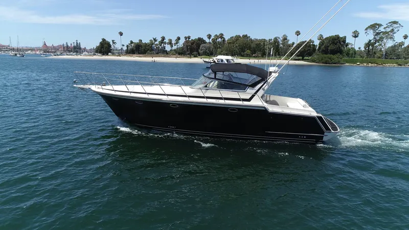 Slide: The Image of 1988 Californian Veneti yacht cruising on a sunny day near a scenic shoreline. - 2