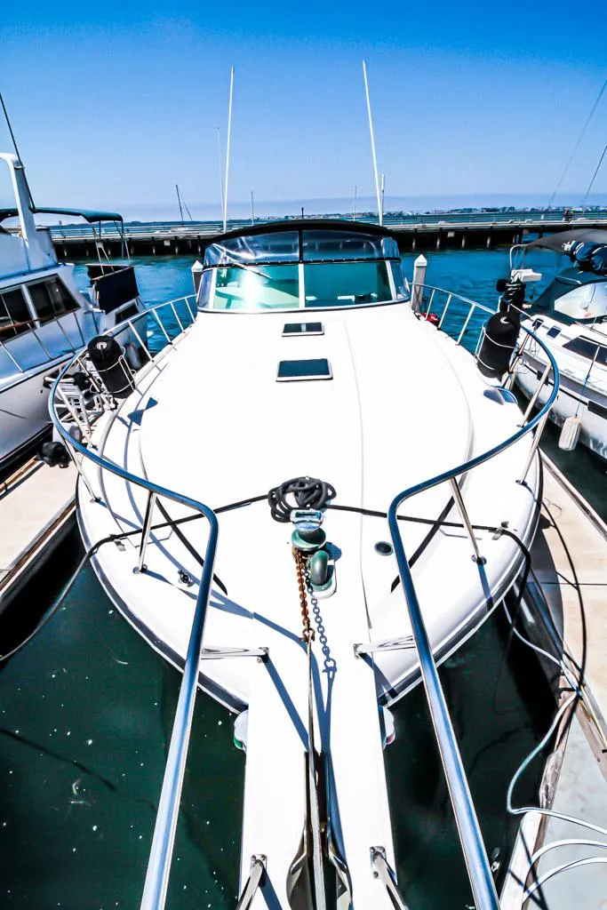 Slide: The Image of 1988 Californian Veneti yacht docked at marina under clear blue sky. - 40