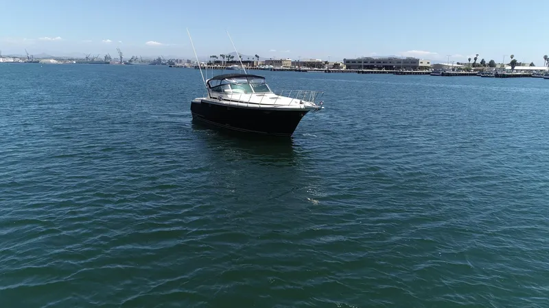 Slide: The Image of A 1988 Californian Veneti boat on calm blue water near a coastal cityscape. - 6