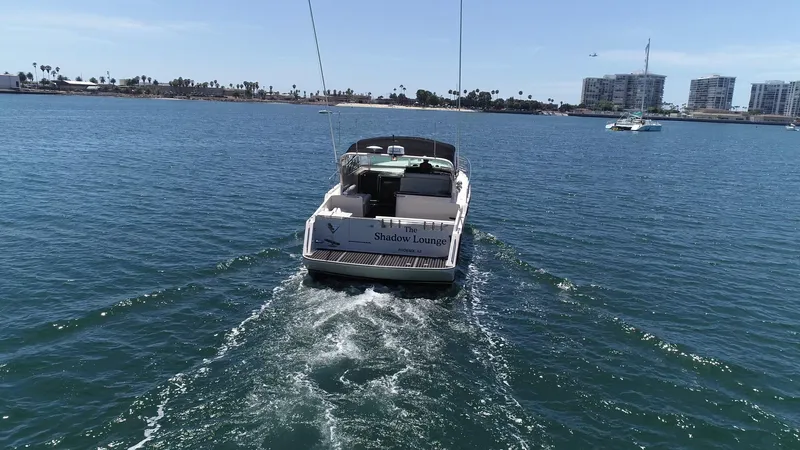 Slide: The Image of 1988 Californian Veneti boat cruising on a sunny day in a coastal city harbor. - 7