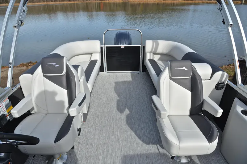 Slide: The Image of 2025 Bennington 22 S pontoon boat interior with plush seating on a calm lake. - 23
