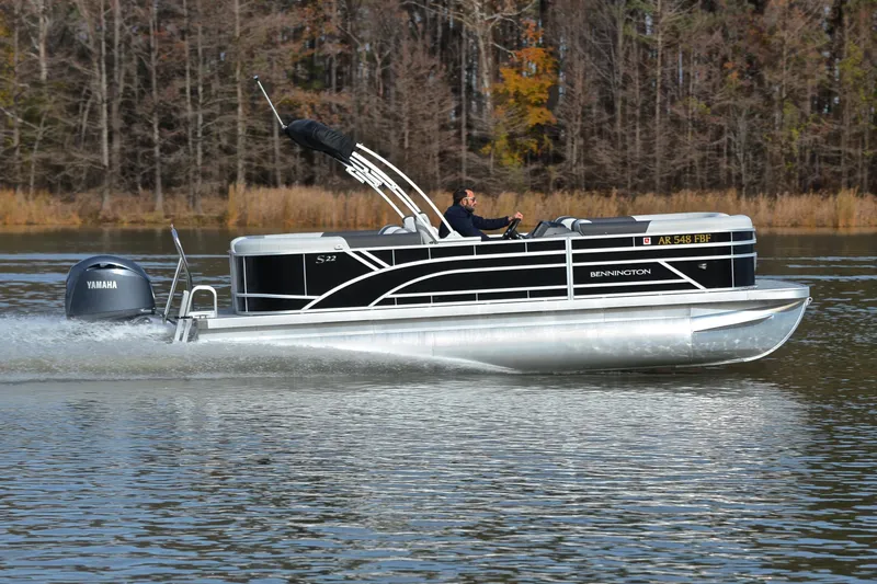 Slide: The Image of 2025 Bennington 22 S pontoon boat cruising on a lake with Yamaha engine. - 3