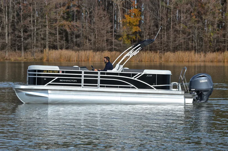 Slide: The Image of 2025 Bennington 22 S pontoon boat on a calm lake with Yamaha motor. - 8