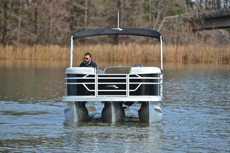 Slide: The Image of 2025 Bennington 22 S pontoon boat cruising on a calm lake. - 9
