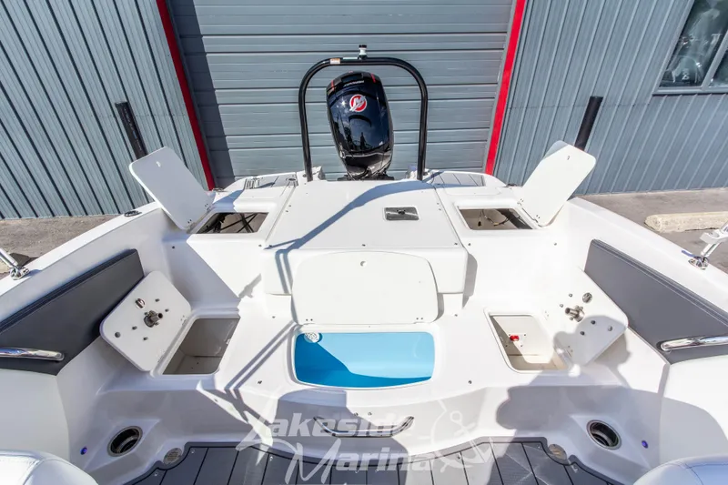 Slide: The Image of 2025 Chaparral 21 SSi Ski & Fish OB boat interior with storage compartments and outboard motor. - 16