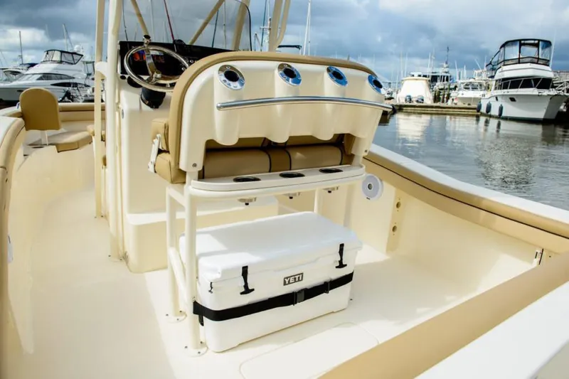 Slide: The Image of 2020 Scout 215 XSF boat with beige seating, parked near a snowy garage. - 14