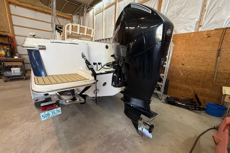 Slide: The Image of 2020 Scout 215 XSF boat with outboard motor in a garage setting. - 31