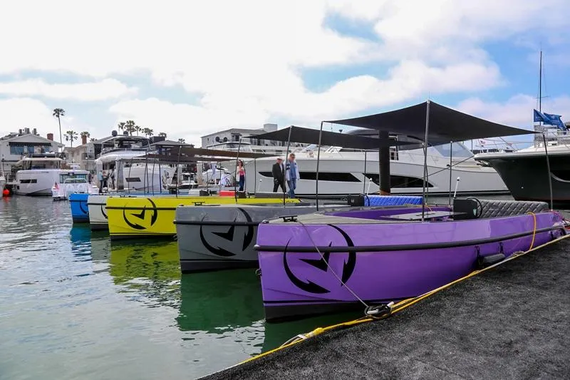 Slide: The Image of Colorful Vision Marine Technologies Volt 180 boats docked, 2023 model, in a marina setting. - 7