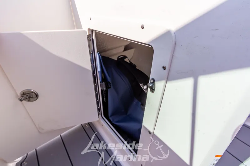 Slide: The Image of Storage compartment on 2025 Chaparral 21 SSi Ski & Fish boat, featuring secure latch. - 27
