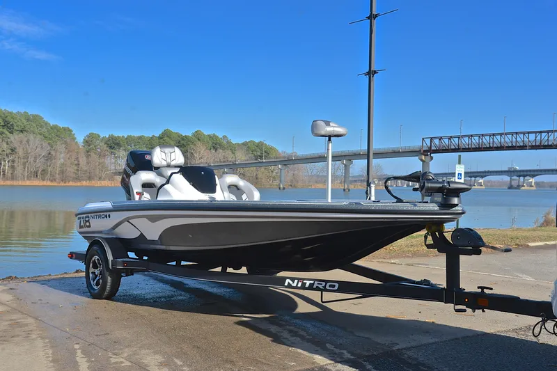 Slide: The Image of 2018 Nitro Z18 Pro boat on trailer by a lake with bridge in background. - 16