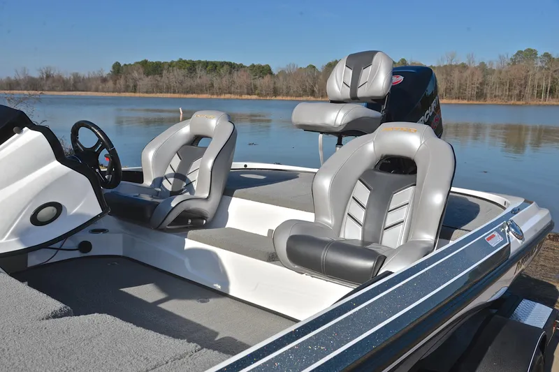 Slide: The Image of 2018 Nitro Z18 Pro boat interior with gray seats by a serene lake. - 18