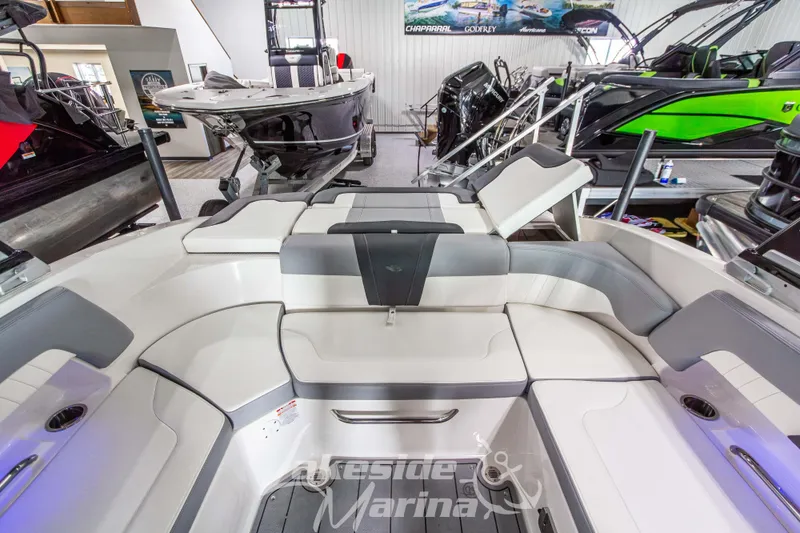 Slide: The Image of 2025 Chaparral 23 SSi boat interior with sleek seating and modern design in showroom. - 15