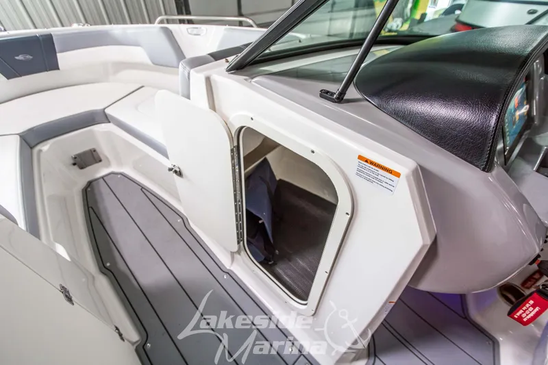 Slide: The Image of 2025 Chaparral 23 SSi boat interior with open storage compartment and sleek seating. - 27