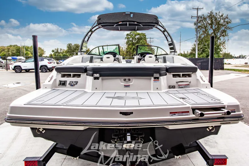 Slide: The Image of 2025 Chaparral 23 SSi boat rear view at Lakeside Marina, showcasing swim platform and seating. - 5