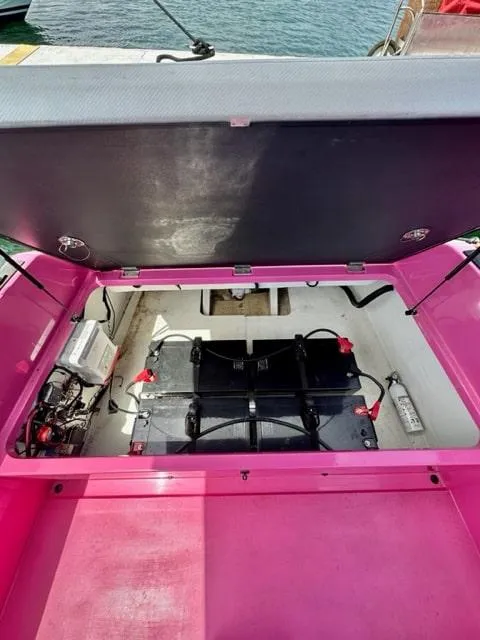Slide: The Image of 2023 Vision Marine Technologies Volt 180 electric boat battery compartment, open lid, pink interior. - 5