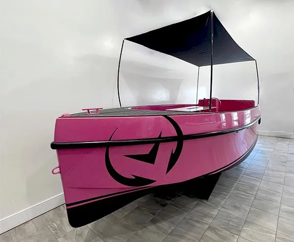 Slide: The Image of 2023 Vision Marine Technologies Volt 180, pink electric boat with canopy, displayed indoors. - 6