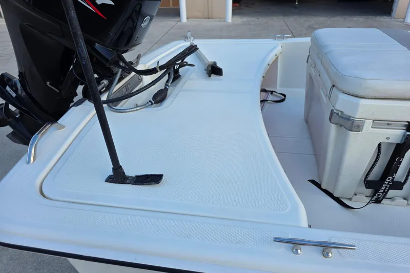 Slide: The Image of 2022 Mako Pro Skiff 15 CC boat deck with motor and cooler. - 4
