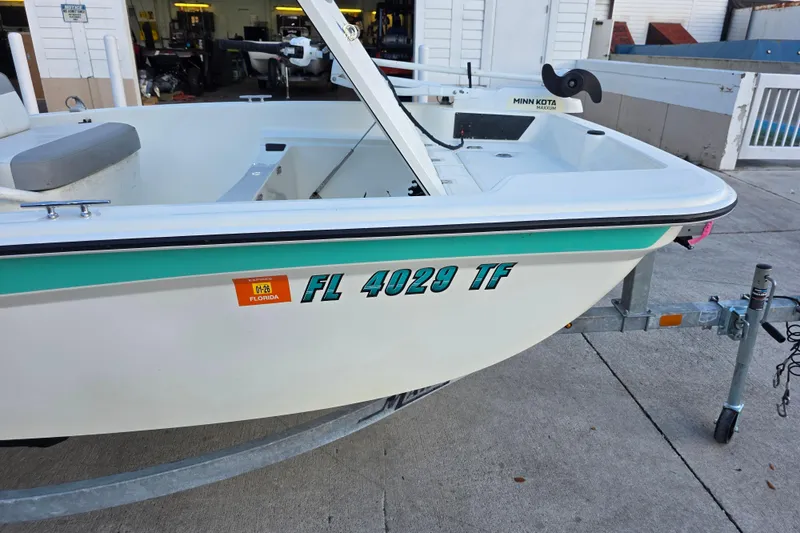 Slide: The Image of 2022 Mako Pro Skiff 15 CC boat on trailer, Florida registration visible. - 5