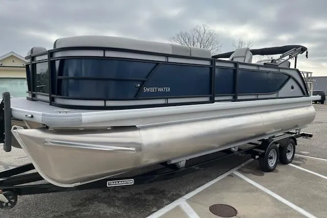 Slide: The Image of 2026 Sweetwater 2286SFLC pontoon boat on trailer in parking lot. - 28