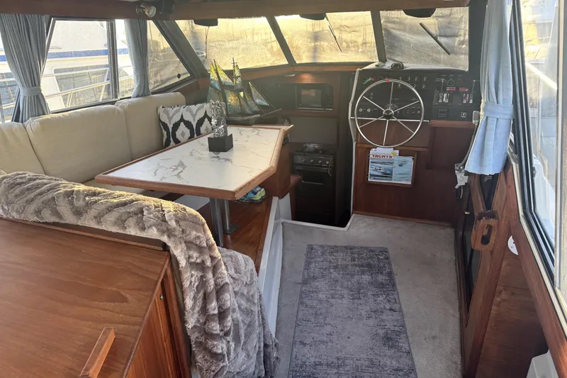 Slide: The Image of 1987 Bayliner 3270 Motoryacht interior with cozy seating, steering wheel, and elegant decor. - 16