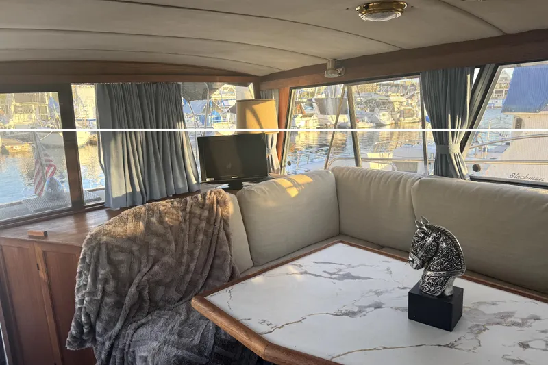 Slide: The Image of Interior of 1987 Bayliner 3270 Motoryacht with cozy seating and decorative horse statue. - 23