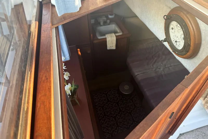 Slide: The Image of 1987 Bayliner 3270 Motoryacht interior with wooden finish, sink, and nautical clock. - 26