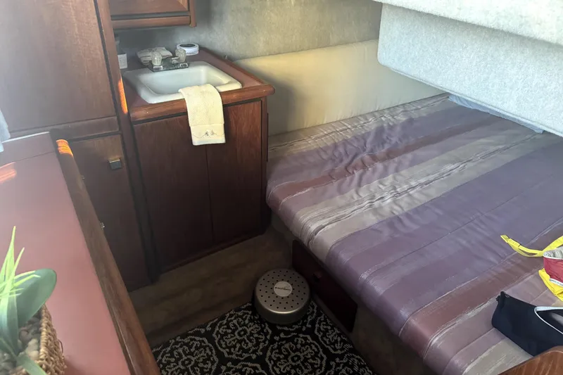 Slide: The Image of 1987 Bayliner 3270 Motoryacht interior with bed, sink, and wooden cabinetry. - 29