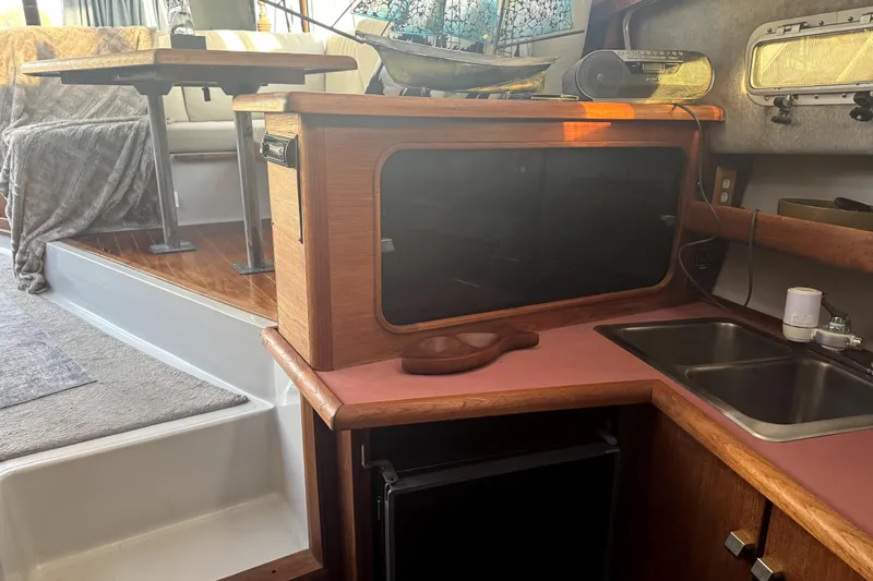 Slide: The Image of 1987 Bayliner 3270 Motoryacht interior with kitchenette, sink, and seating area. - 31