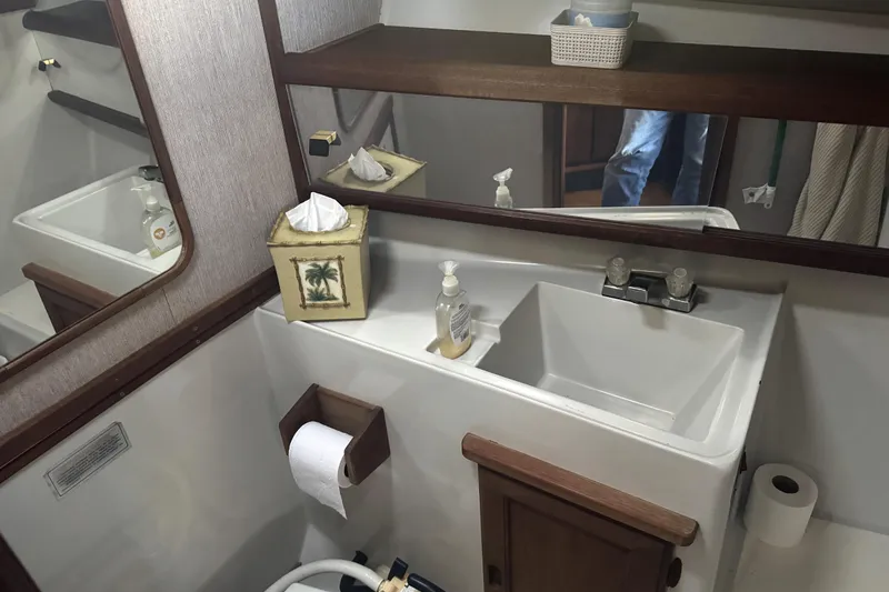 Slide: The Image of 1987 Bayliner 3270 Motoryacht bathroom with sink, mirror, and wooden accents. - 37