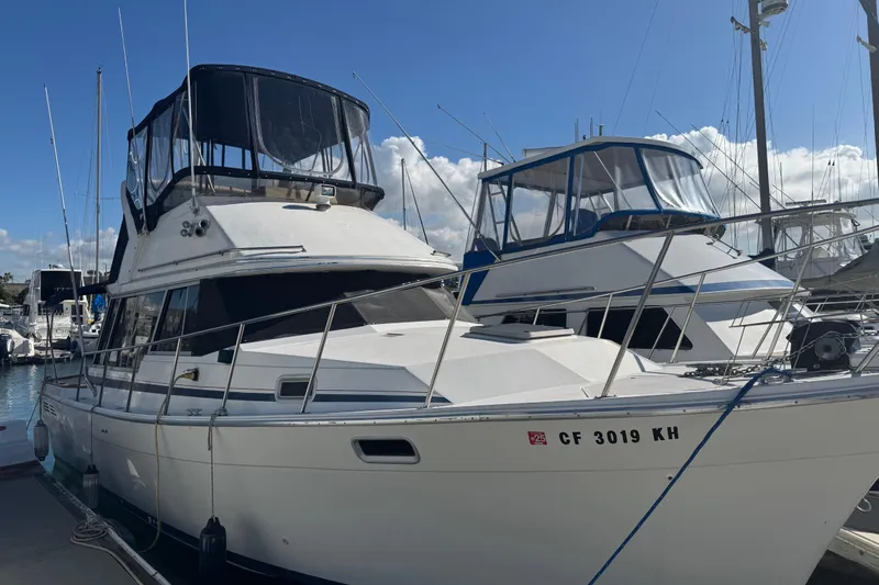 Slide: The Image of 1987 Bayliner 3270 Motoryacht docked at marina under clear blue sky. - 41