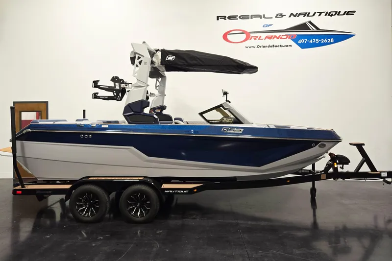 The Image of 2026 Nautique Super Air Nautique GS20 boat on trailer, blue and white design. - 0
