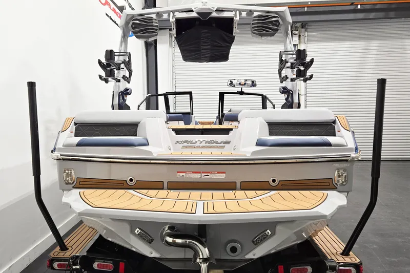 Slide: The Image of 2026 Nautique Super Air Nautique GS20 boat, rear view in a showroom setting. - 3