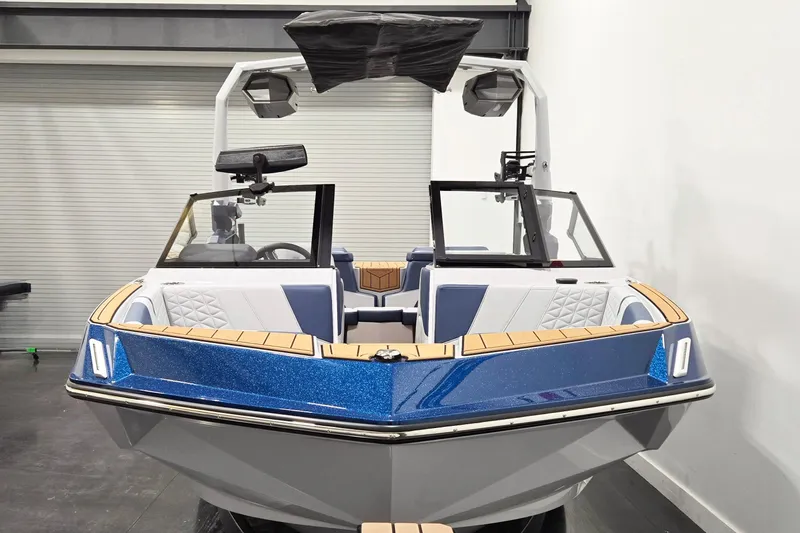 Slide: The Image of 2026 Nautique Super Air Nautique GS20 boat, blue and white, in a showroom setting. - 4