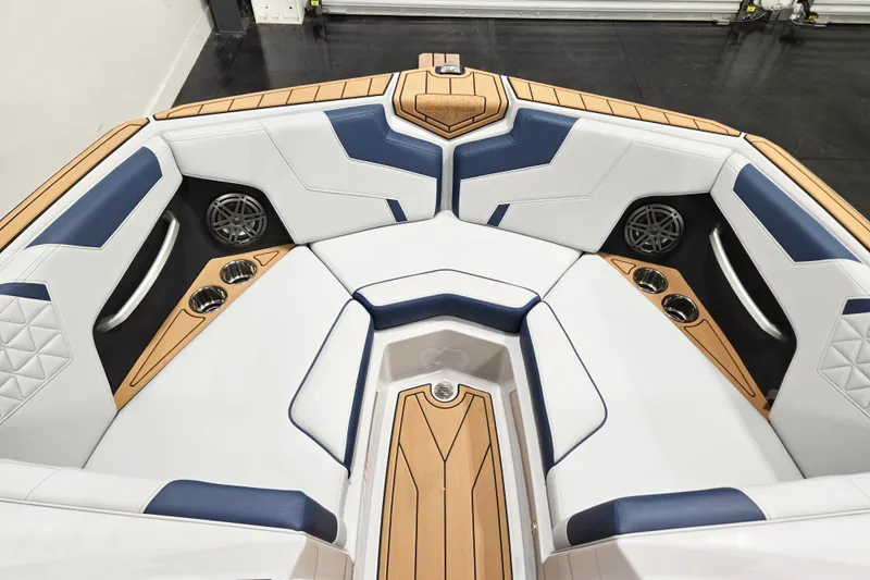 Slide: The Image of 2026 Nautique Super Air Nautique GS20 boat interior with white and blue seating, cup holders, and speakers. - 9