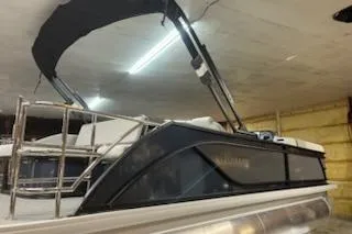 Slide: The Image of 2026 Sweetwater 2286SFL pontoon boat with canopy in indoor storage. - 9