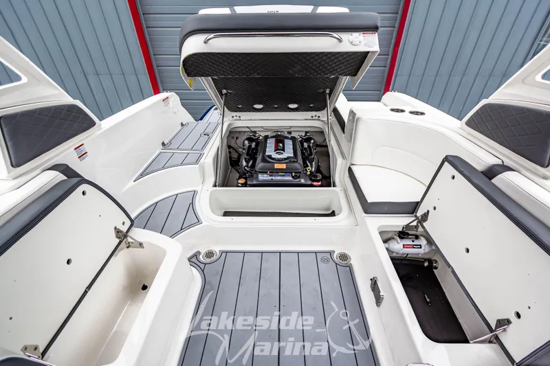 Slide: The Image of 2025 Chaparral 247 SSX boat interior with open engine compartment and storage areas. - 14