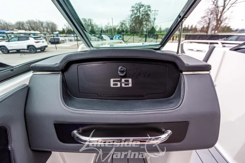 Slide: The Image of 2025 Chaparral 247 SSX boat dashboard with storage compartment and handle. - 25