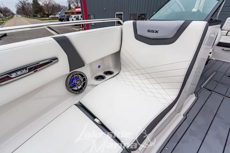 Slide: The Image of 2025 Chaparral 247 SSX boat interior with white seating and speaker detail. - 36