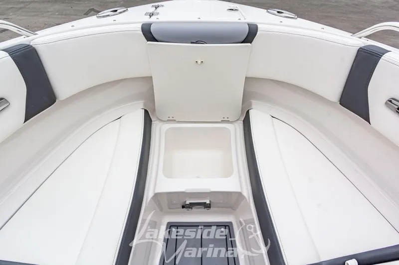 Slide: The Image of 2025 Chaparral 247 SSX boat interior with white seating and storage compartment. - 38
