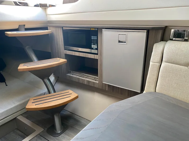Slide: The Image of 2021 Sea Ray SLX 400 Outboard cabin interior with stairs and kitchenette. - 17