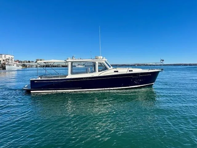 The Image of 2014 MJM 36z Downeast boat on calm water under clear blue sky. - 0