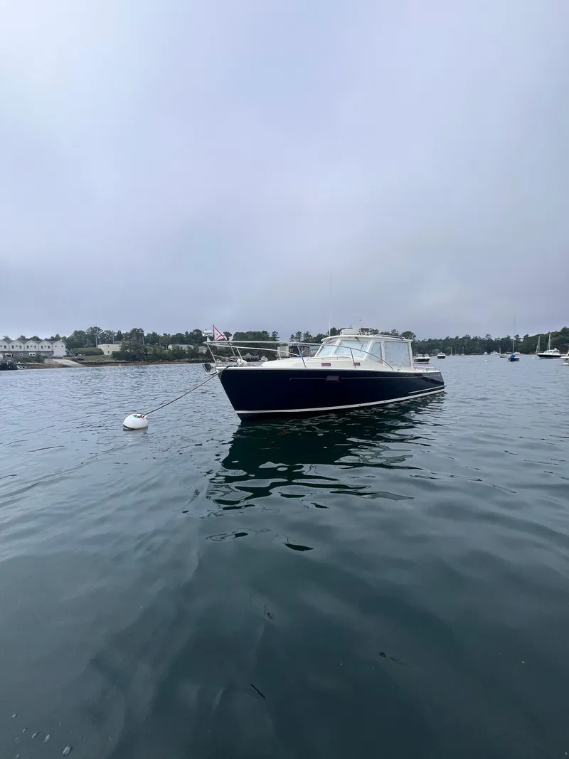 Slide: The Image of 2014 MJM 36z Downeast boat anchored on calm water under cloudy sky. - 23