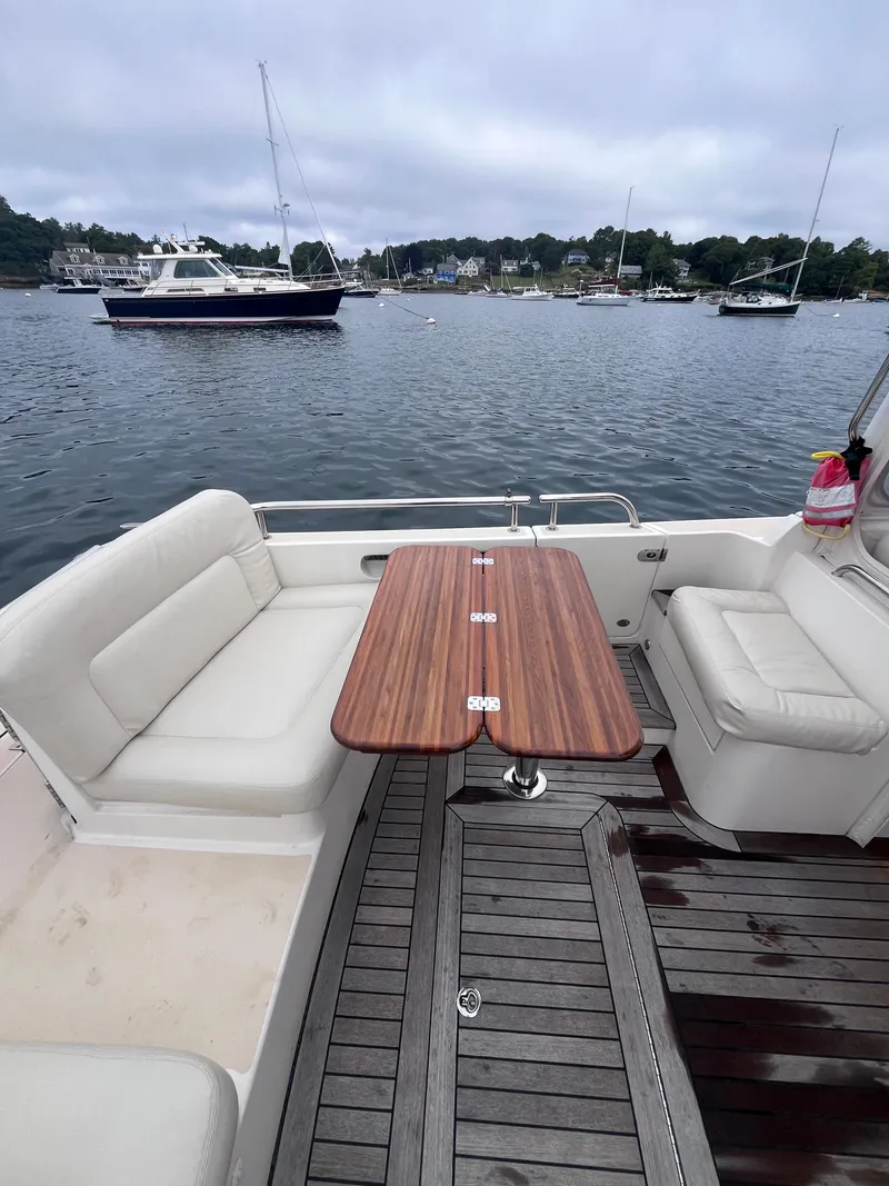 Slide: The Image of 2014 MJM 36z Downeast boat with teak table and seating, docked in a scenic harbor. - 36