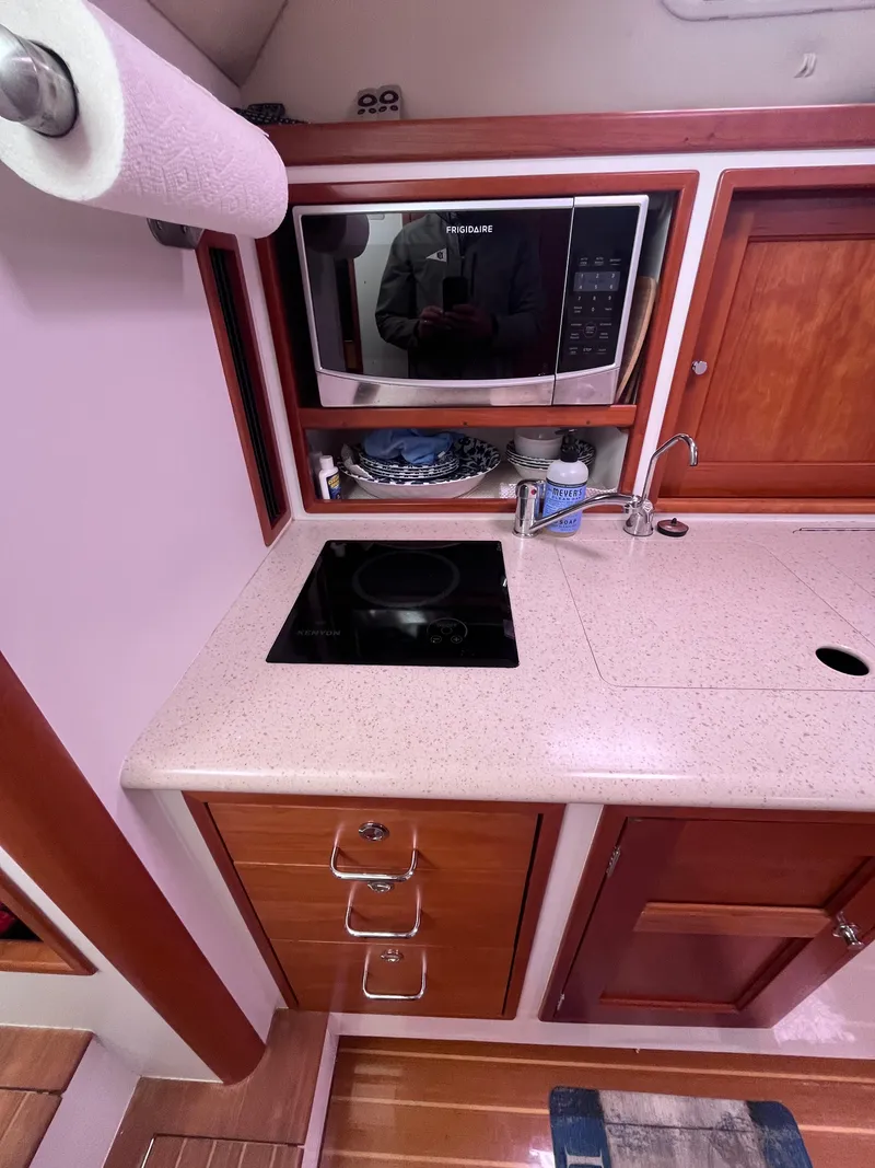 Slide: The Image of 2014 MJM 36z Downeast boat kitchen with microwave, stove, and wooden cabinetry. - 46