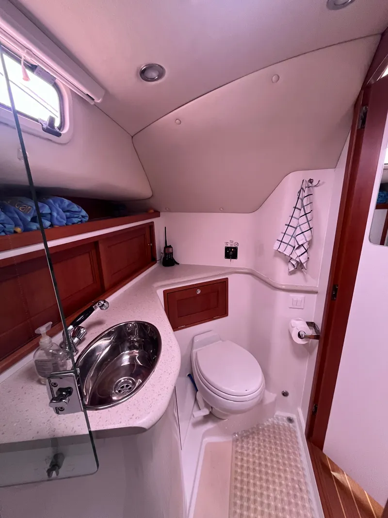 Slide: The Image of 2014 MJM 36z Downeast yacht bathroom with sink, toilet, and wooden cabinetry. - 49