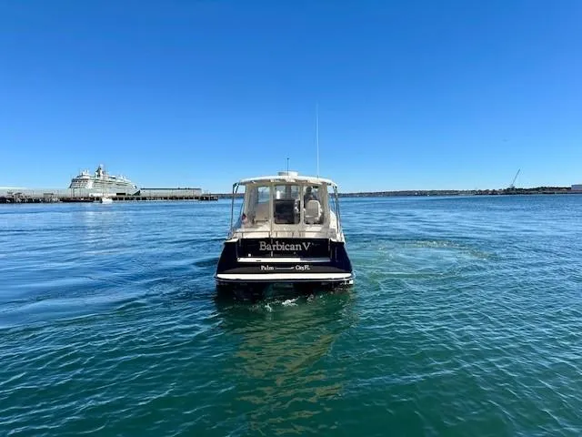 Slide: The Image of 2014 MJM 36z Downeast boat on clear blue water, distant cruise ship in background. - 5