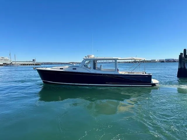 Slide: The Image of 2014 MJM 36z Downeast boat on calm water under clear blue sky. - 8