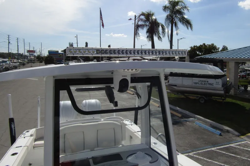 Slide: The Image of 2025 Sea Hunt Ultra 275 SE boat with T-top and LED light bar in a marina setting. - 14