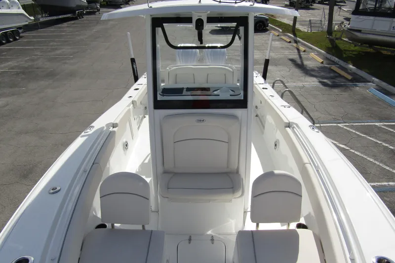 Slide: The Image of 2025 Sea Hunt Ultra 275 SE boat interior with seating and console, parked in a lot. - 16